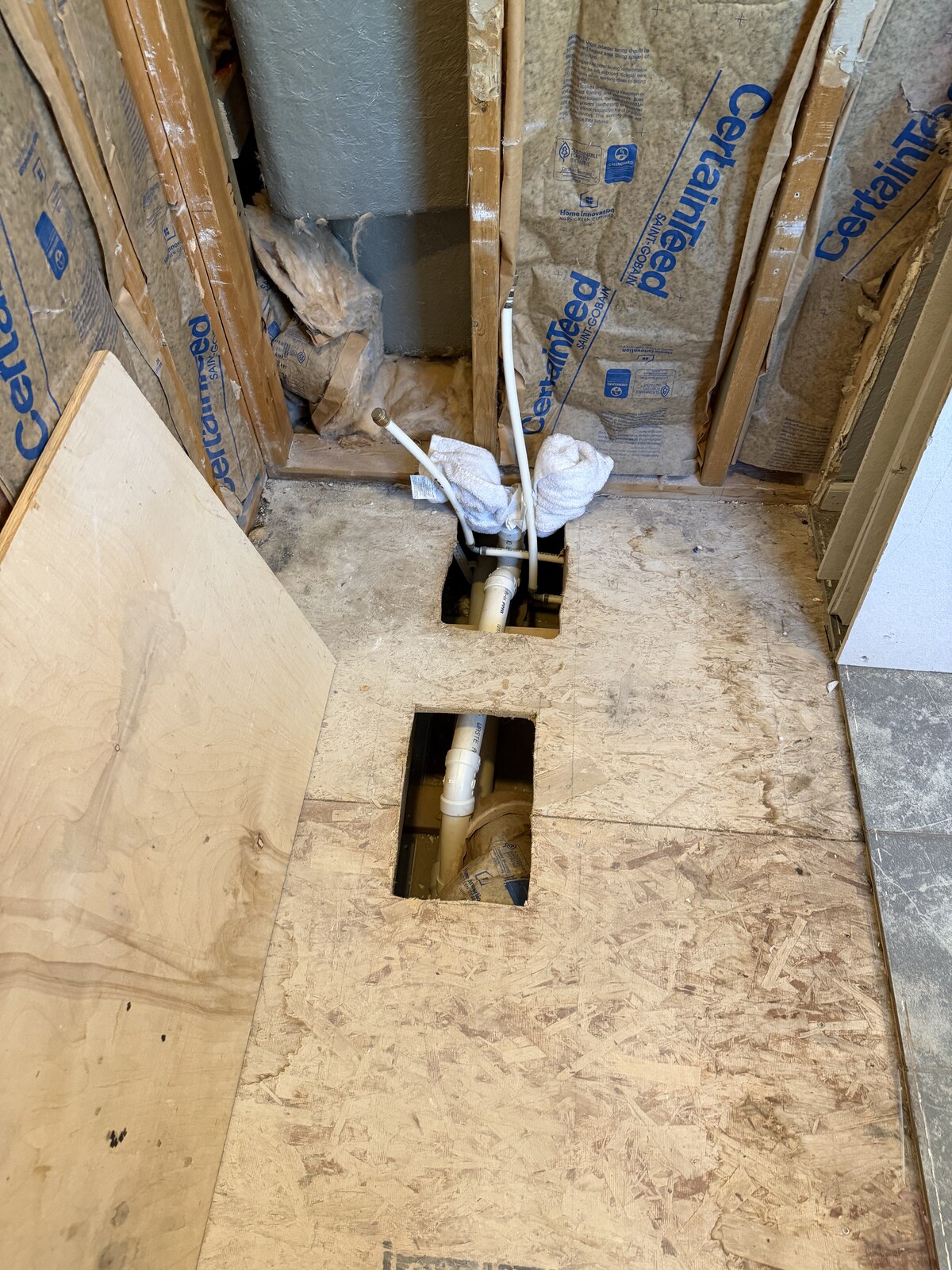 Close view of the open floor and plumbing access before the tub is fitted.