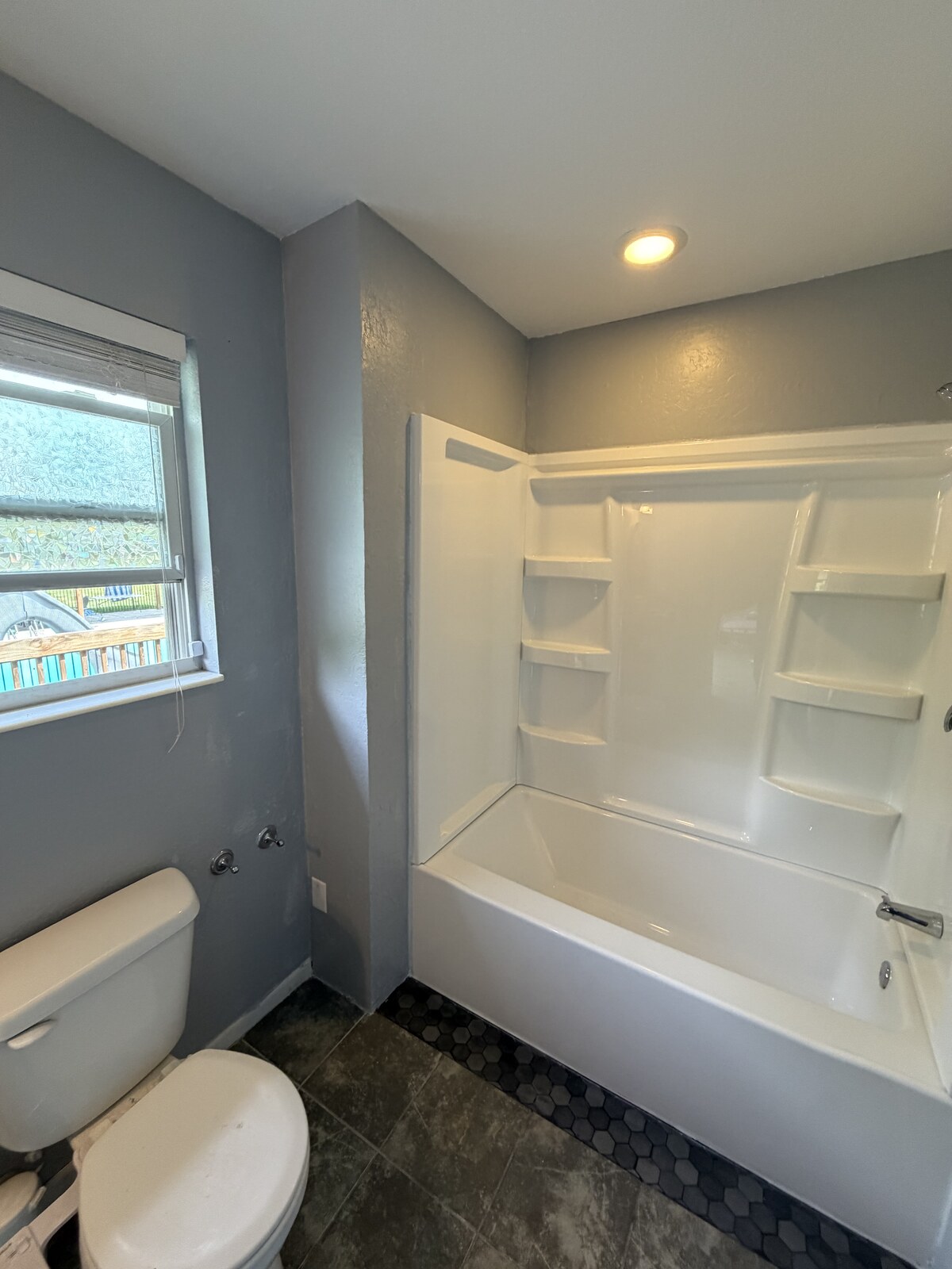 Finished tub surround, painted walls and flooring.