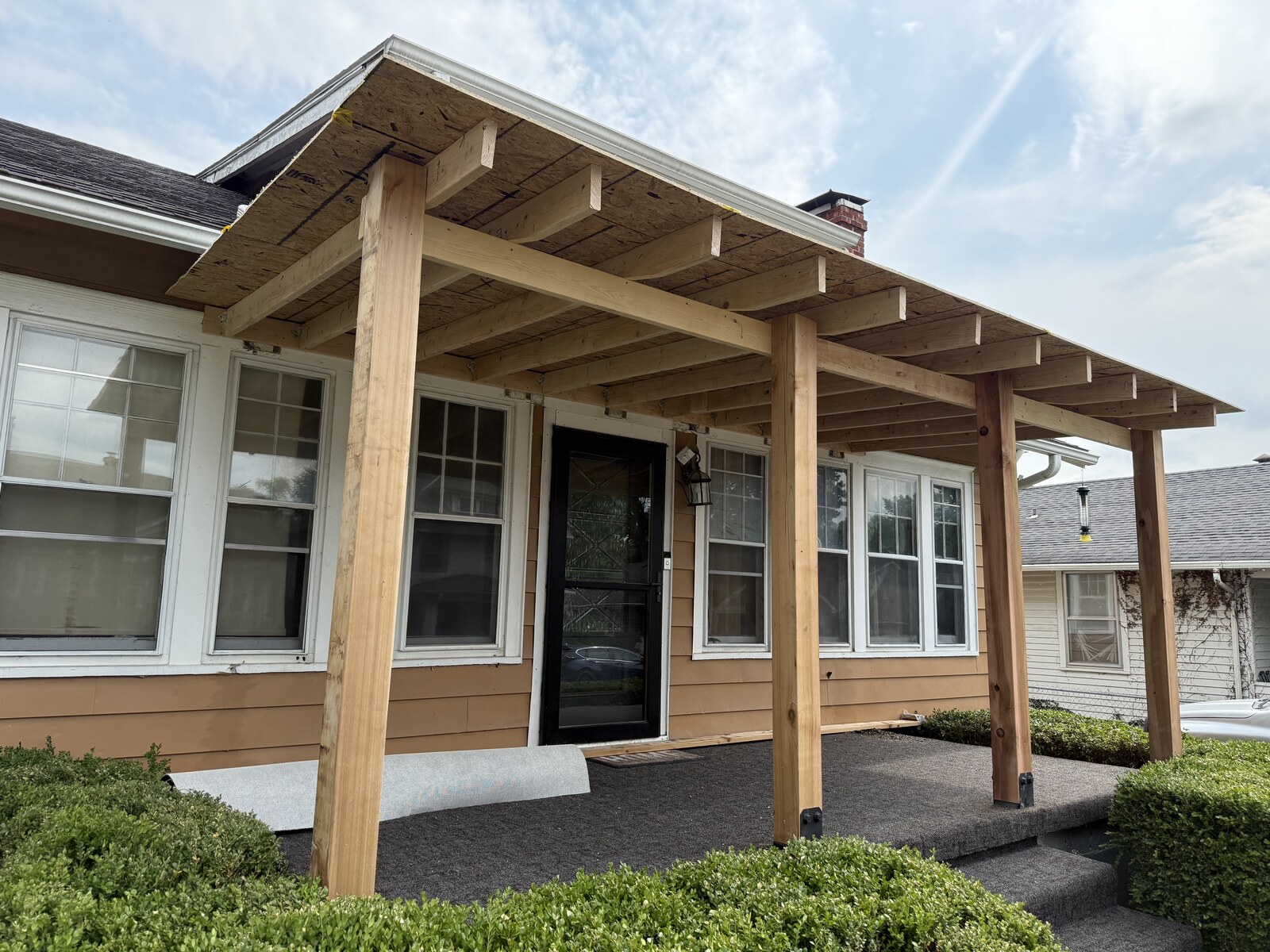 Posts, beams and exposed framing establish the new porch roof.